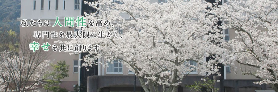桜が満開の木の枝とその後ろに病院の外観「私たちは人間性を高め、専門性を最大限に生かし、幸せを共に創ります」